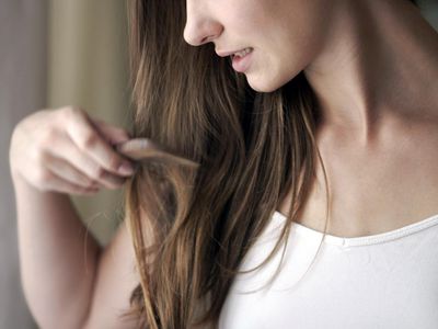 Young woman combing hair