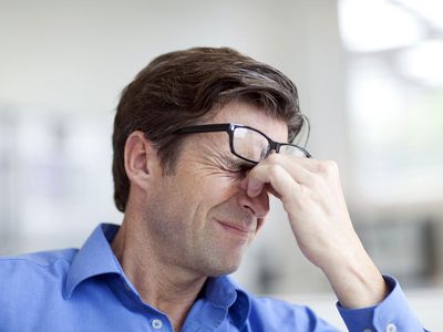 Mature man wincing with a headache