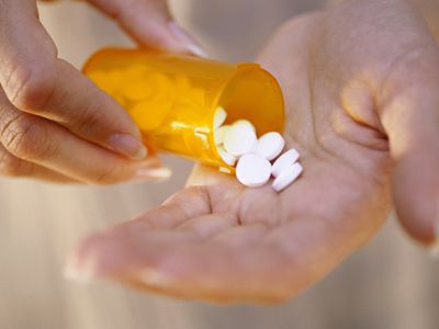 Woman holding bottle of clomid pills in hand