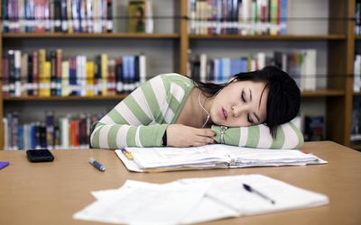 Teenage girl sleeping in school library