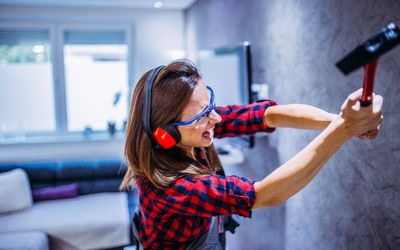 Woman smashing wall with hammer: do anger rooms help or hurt?