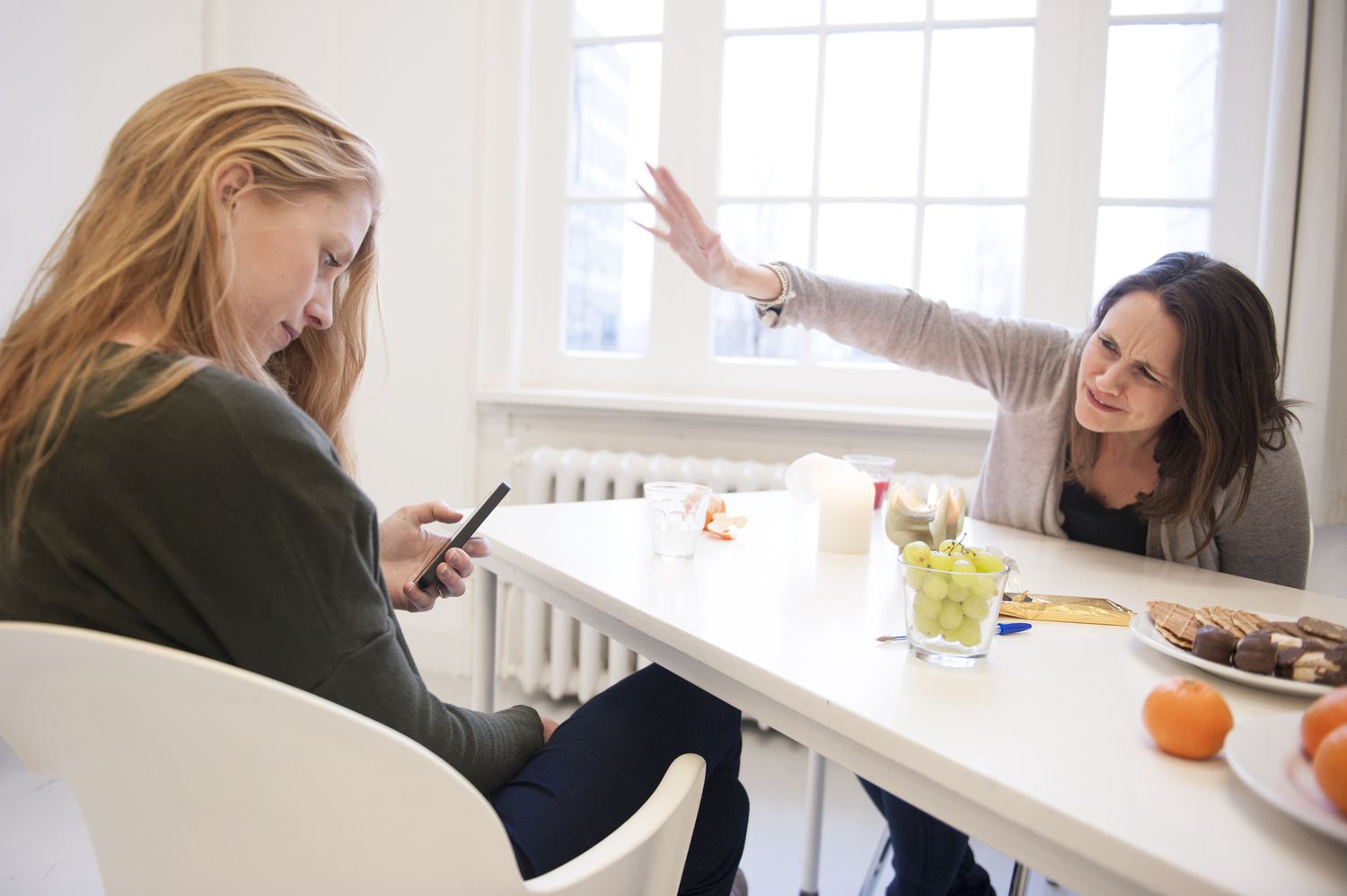 Woman ignores companion while she looks at her phone