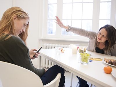 Woman ignores companion while she looks at her phone