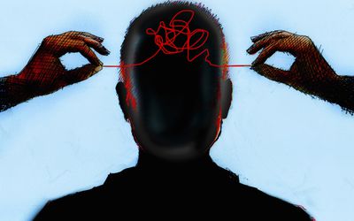 Hands untangling thread from inside of mans head