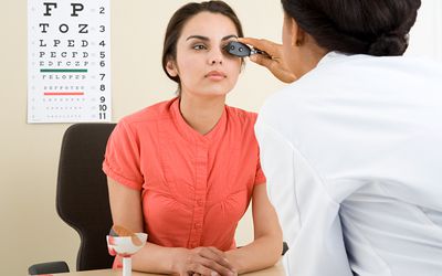 a woman having her eyes examined by a doctor