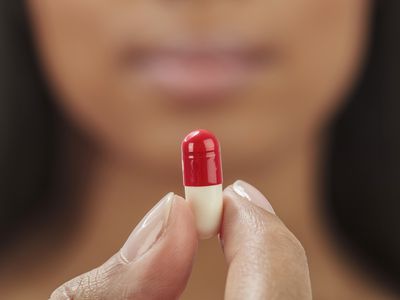 Close up of mixed race woman holding medication capsule