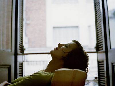 woman lying back in her chair relaxing with eyes closed