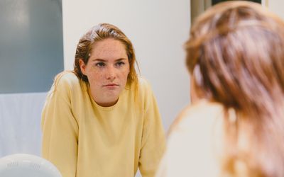 Depressed Teen Looks At Herself in Bathroom Mirror