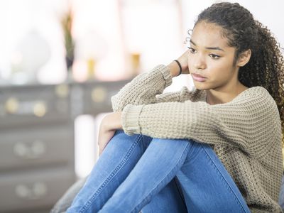 Sad teen sitting on bed