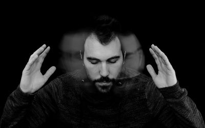 Digitally Generated Image Of Man Shaking Head Against Black Background