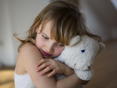 Sad girl hugging a stuffed animal