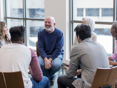 Diverse people sitting in a circle during group therapy