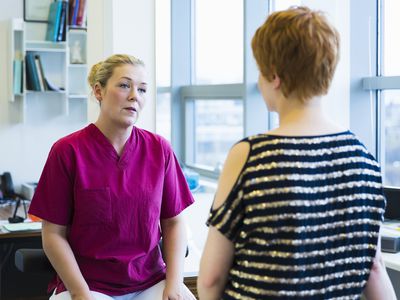 A doctor and patient talk in a hospital.