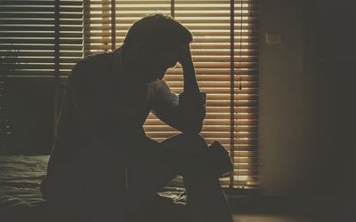 Sad man sitting in dark room