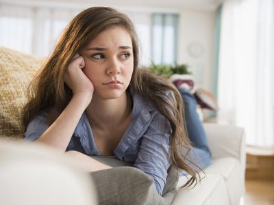 Sad girl laying on a couch