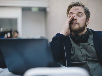 Fatigued man rubbing his eyes