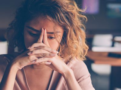 sad woman clasping hands together