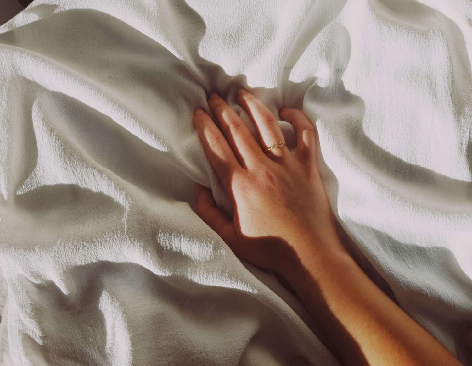 woman's hand on bed