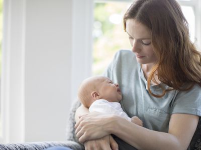 Mother looking at crying newborn baby at home