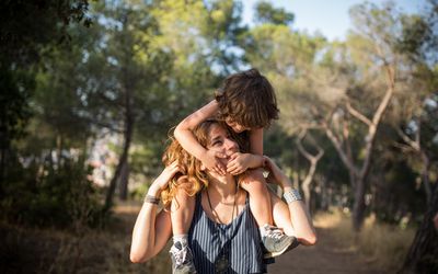 Mom carrying baby boy on her shoulders 