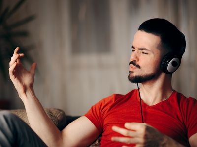 Happy guy listening to music doing air guitar gesture