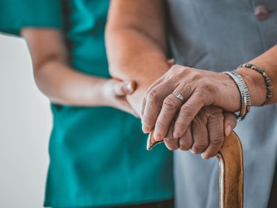 woman in nursing home helping elderly woman