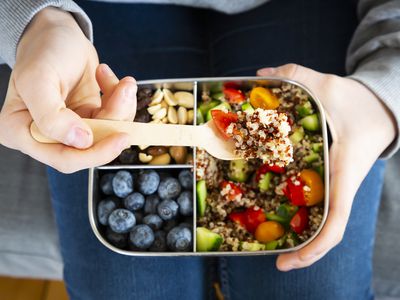 Lunchbox with quinoa salad with tomato and cucumber, blue berry and trail mix