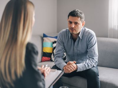 A photography of a man talking to his therapist.