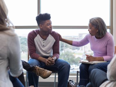 Mature grandmother lays hand on teen grandson to reassure him