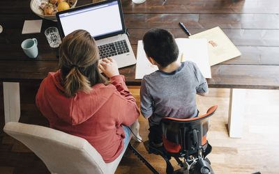 High angle view of mother with autistic son watching video on laptop while sitting at home