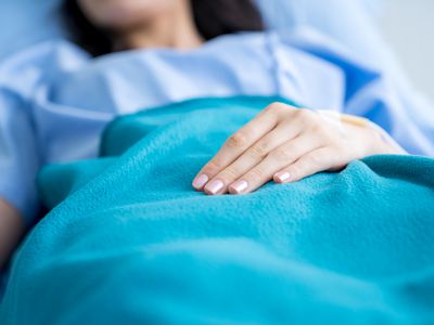 Close-up hands of patient recovering on the hospital bed