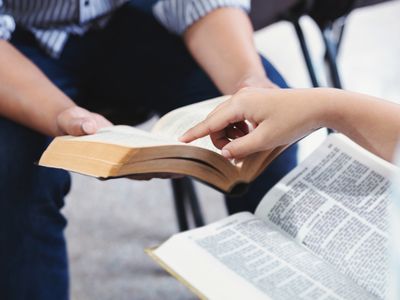 Midsection Of Woman Reading Book On Paper