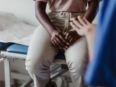 Midsection of female healthcare worker explaining to young patient in medical clinic