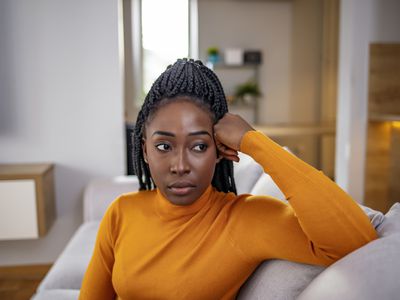  Young attractive and sad black African American woman sitting depressed at home 