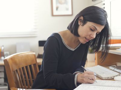 woman writing at home office desk