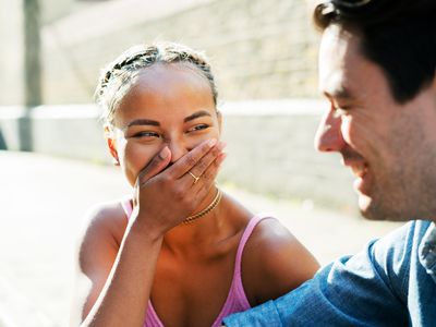 Woman in pink dress laughing at something male companion says