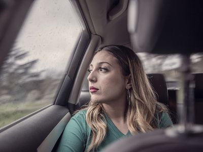 Woman riding in a car looking out the window.