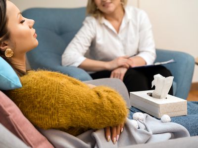 Positive blonde middle-aged woman psychologist talking to girl patient