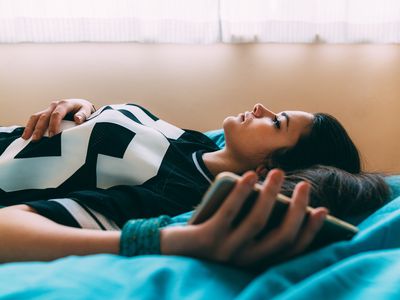 Woman lying on bed feeling depressed.