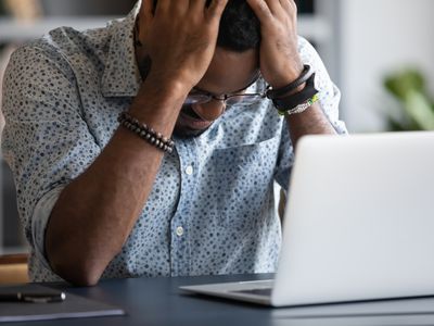 Stressed biracial man frustrated by work problems