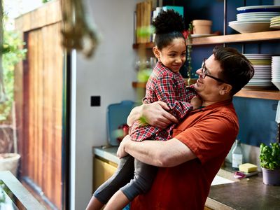 Affectionate father holding young daughter at home, love, family, nurturing