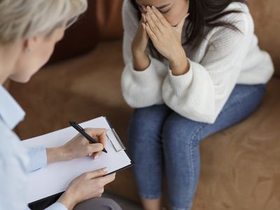 Psychologist Taking Notes Talking With Crying Woman In Office, Cropped 