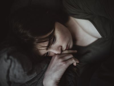 White woman lying down appearing sad