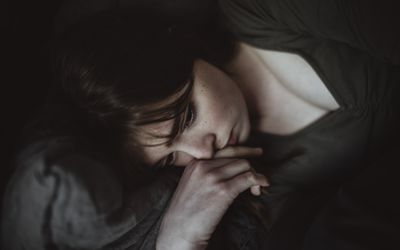 White woman lying down appearing sad