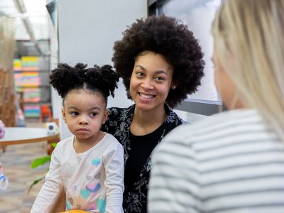 Beautiful young mother and her toddler daughter meet with friends during support or play therapy group