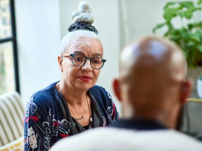 Senior woman with hair bun listening to friend