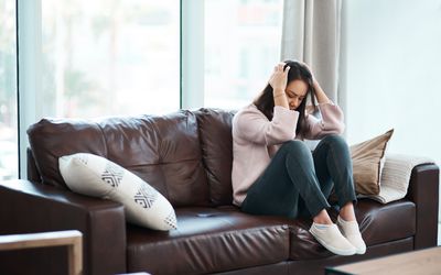 Shot of a young woman experiencing mental anguish at home