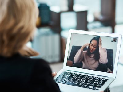 Shot of a young woman having a counselling session with a psychologist using a video conferencing tool