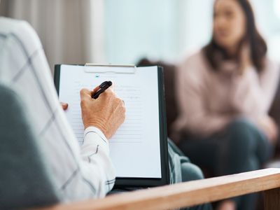 Cropped shot of a psychologist writing notes during a therapeutic session with her patient