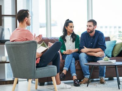 Shot of two young men and a woman having a discussion in a modern office